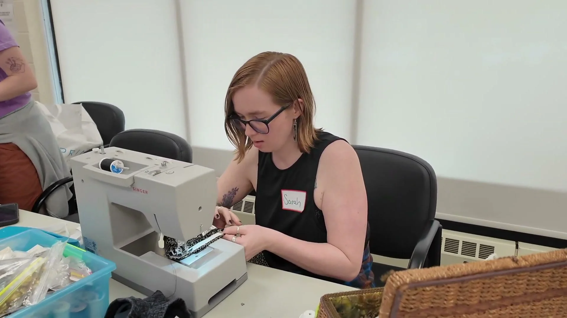 A volunteer helping mend a garment at a repair event
