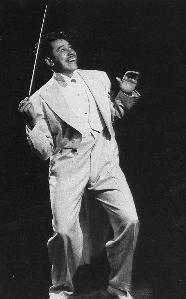Cab Calloway conducting in a white suit.